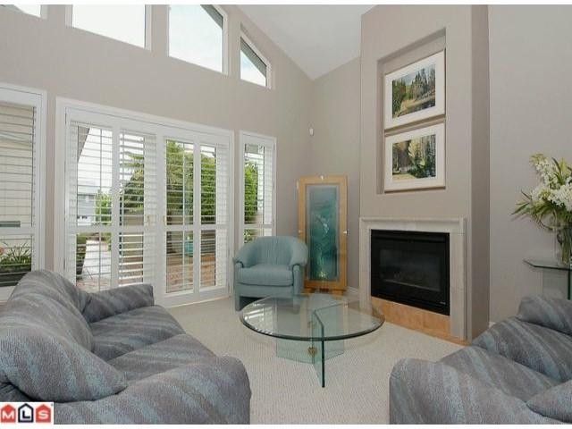 Light & bright high ceilings & cozy fireplace with french doors to patio enhance this lovely livingroom.