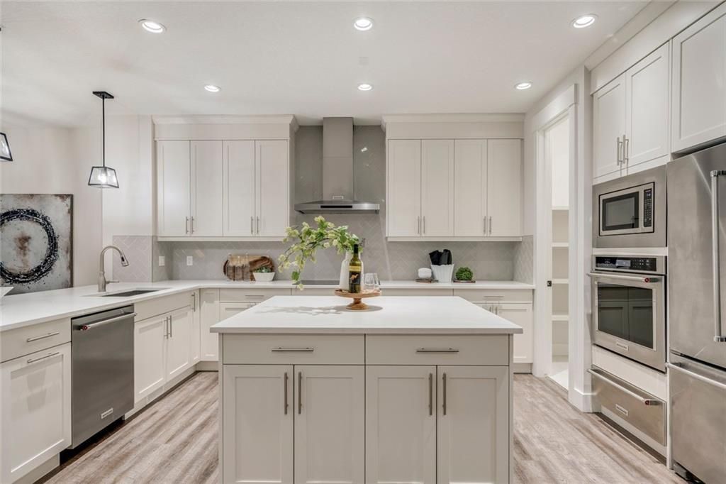Fully custom kitchen complete with central island, full height cabinets, built in wall oven, 36" induction cook top, pot fill and herringbone backsplash.