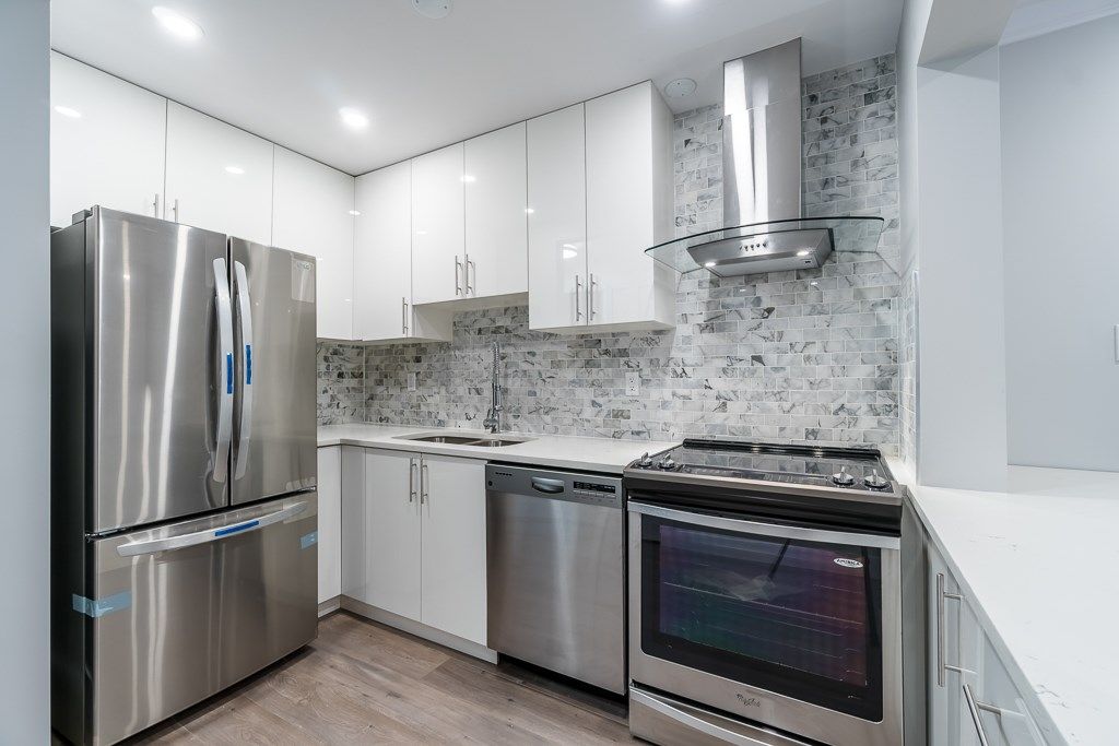 Complete renovated kitchen with backsplash tiles and stainless steel appliance.