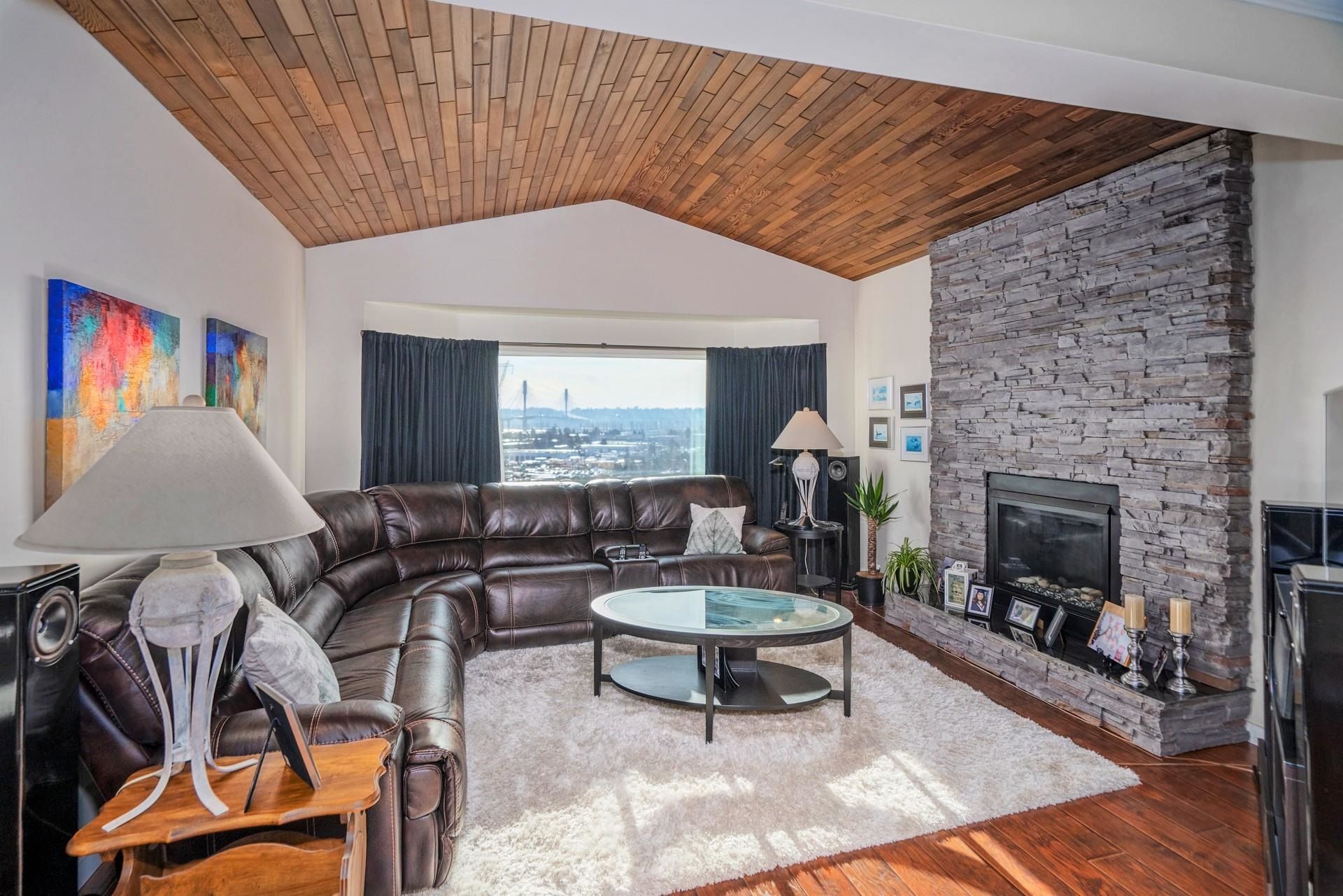 Huge Living Room with Amazing Unobstructed Views of Mt. Baker, Cascade Mountains & Port Mann Bridge. Gorgeous floor to ceiling stone gas fireplace; beautiful wood cedar vaulted ceiling; engineered wood floor throughout.