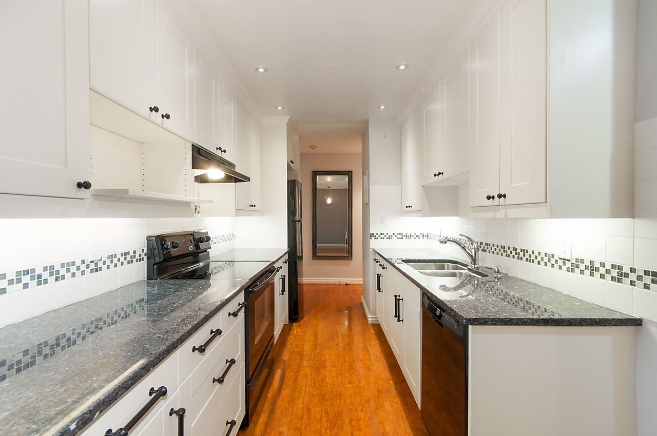Crisp white shaker cabinets offer ample storage and black granite counters provide lots of working space for the chef.