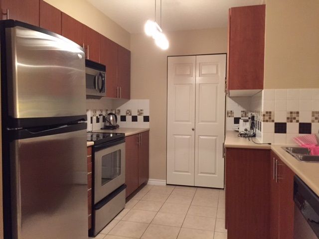 Spacious Kitchen with stainless steel fridge and stove, lots of storage space including pantry.