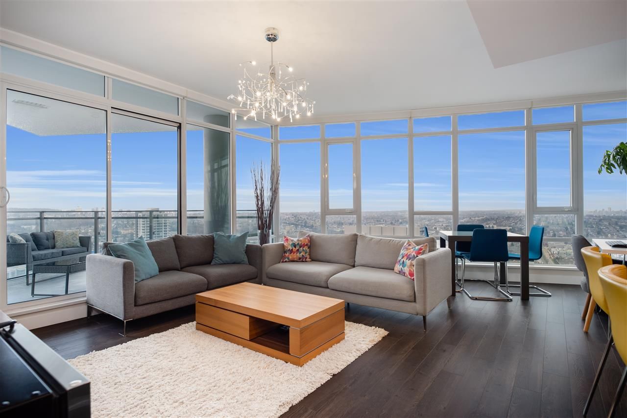Large living room surrounded by south and southwest facing floor to ceiling windows for year round sunlight, warmth, and unobstructed views.